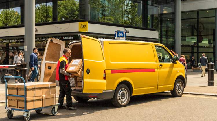 Courier unloading parcels from a yellow van, highlighting package delivery services to and from Taiwan.