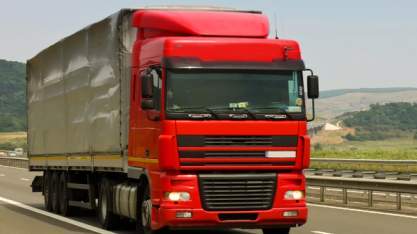 Red truck on the highway for international road freight import and export services